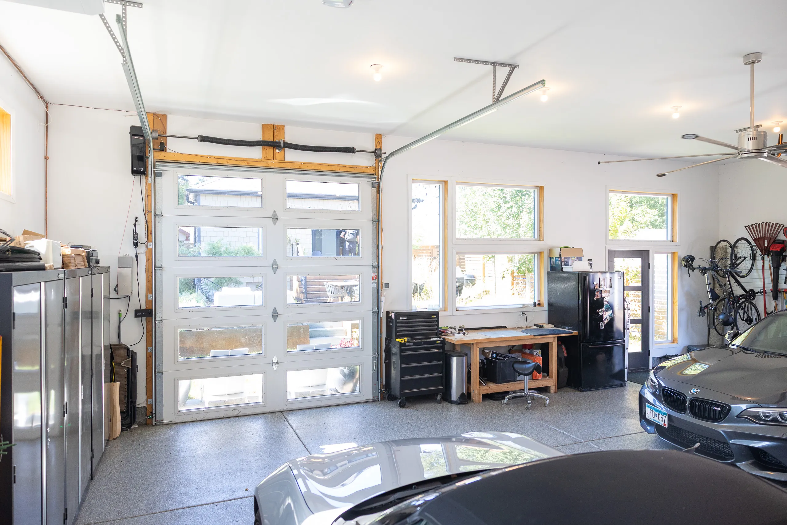 Finished three-car garage interior with workshop, glass-panel overhead door and storage