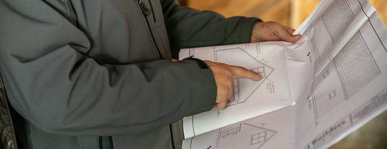 person looking a garage blueprints