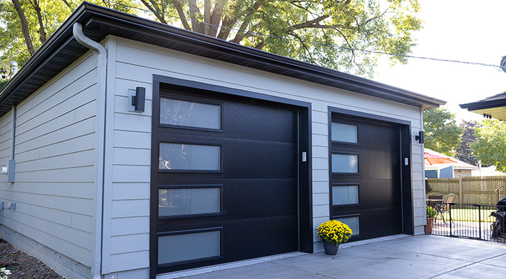 Red detached three-car garage with tan garage doors.
