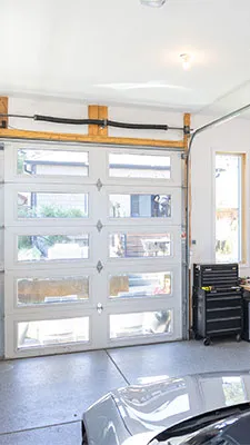 Finished garage interior with a full-view glass garage door and coated floor