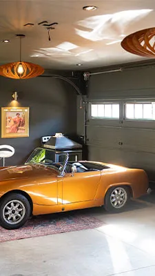 Finished custom garage interior with an orange classic car and decorative lighting